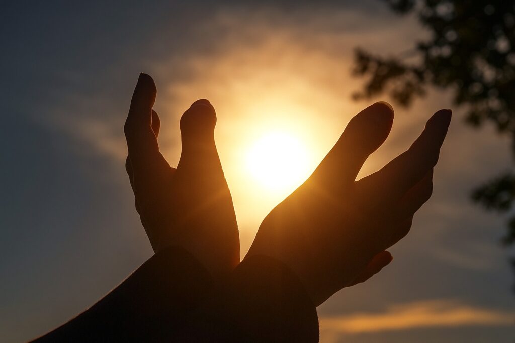 Symbolische foto van handen in het zonlicht, passend bij het thema Energy Healing.